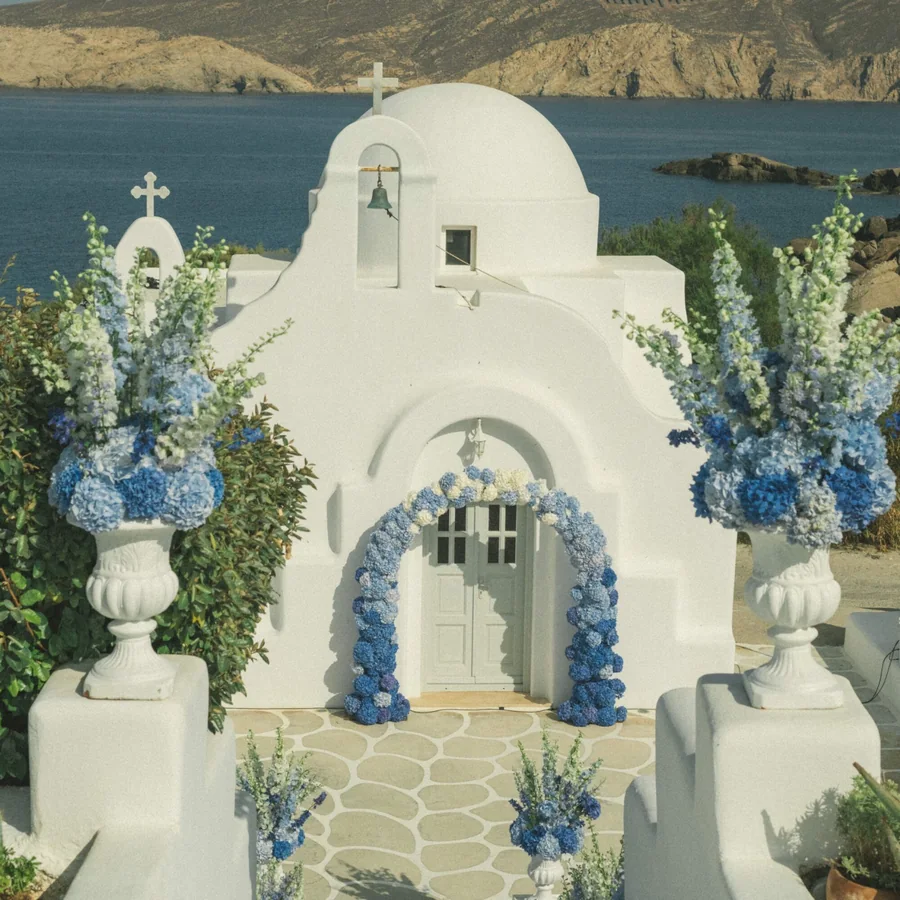 Whitewashed Mykonos chapel dressed with blue and white flowers for a wedding