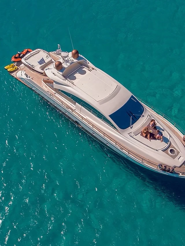 Motor yacht at anchor on turquoise water, seen from above