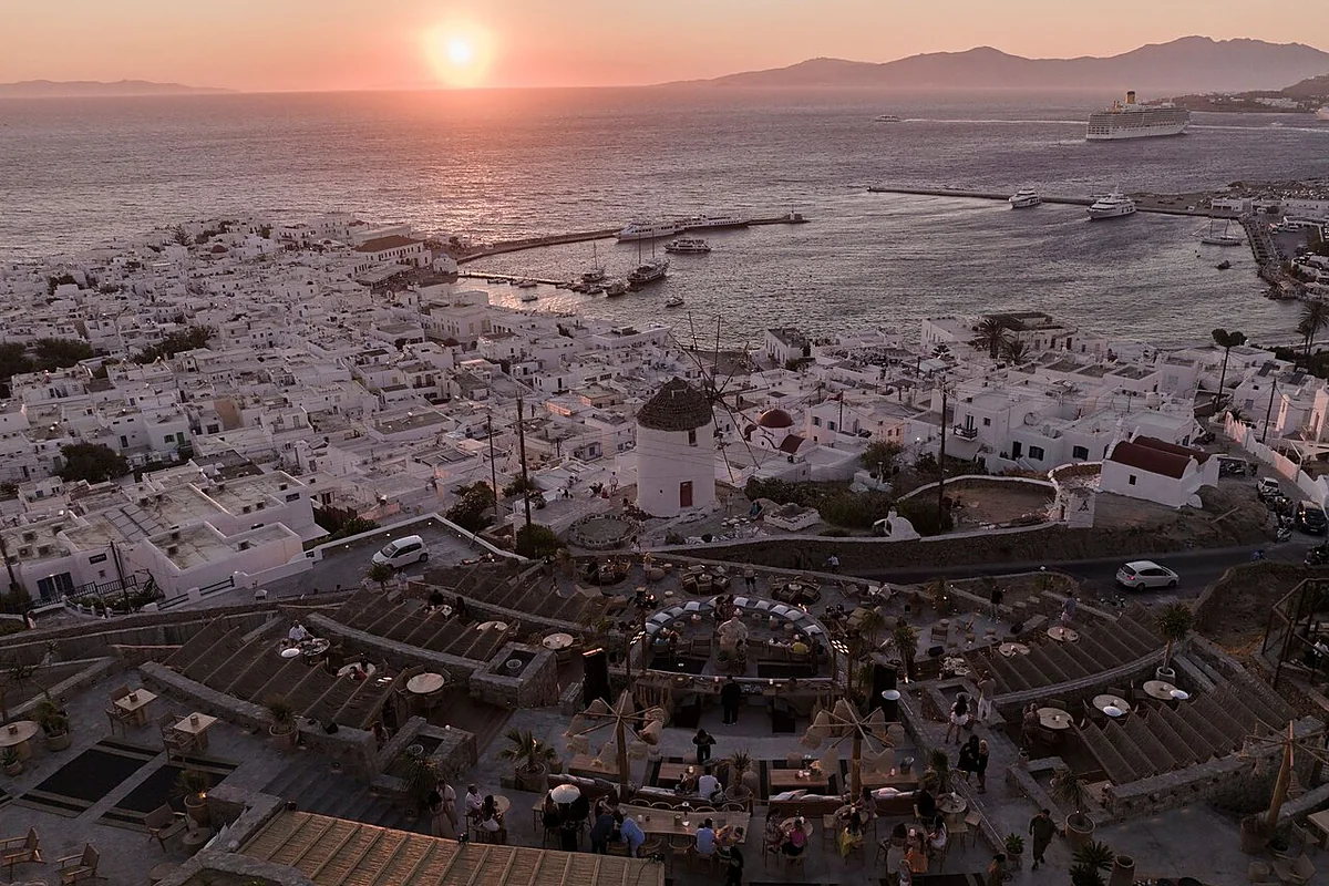 Sunset over Mykonos Town seen from a hillside bar