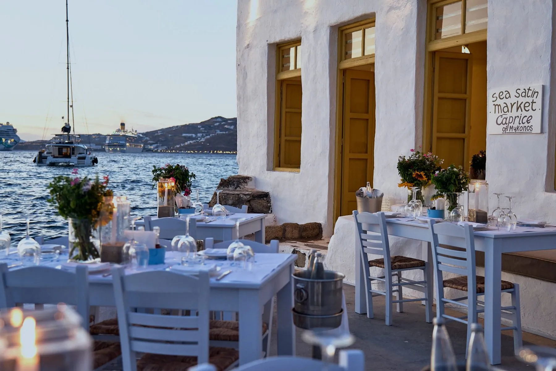 Tables set by the water in Little Venice, Mykonos